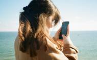 Una joven mira su teléfono de cerca. Foto: Unsplash, minusculemarie